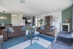 A modern living room with two sofas, a coffee table, and a fireplace.