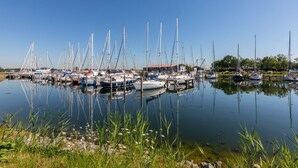 A marina with multiple boats docked, calm water, and greenery around. - Welcoming Family Home (Wolphaartsdijk)