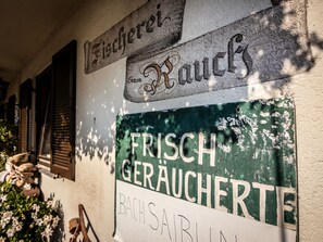 A building facade with signs indicating 'Frisch Geraucherte' and 'Bachsabl.' - Fisherman's House Comfortable Holiday Residence (Dießen am Ammersee)