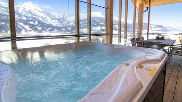 A hot tub with a view of snow-capped mountains. - Spacious Apartment With Sauna (Haus)
