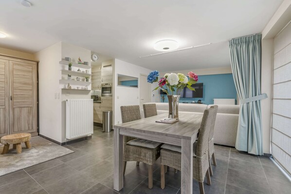 A modern kitchen with white cabinets, a built-in oven, and a white countertop.