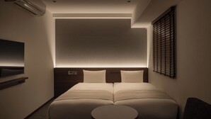 A modern hotel room with a large bed, a small round table, and a TV mounted on the wall. - Nest Hotel Tokyo Yaesu (Tokyo)