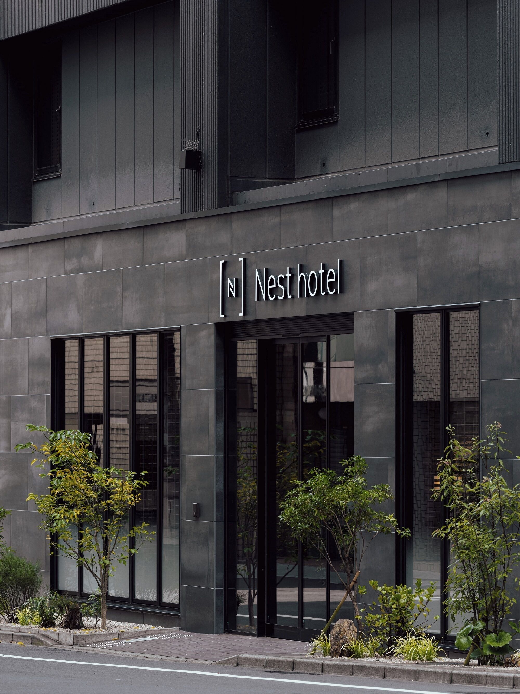 Un edificio moderno con un letrero que dice "Nest hotel".