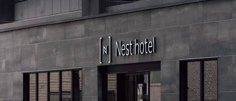 Un edificio moderno con un letrero que dice "Nest hotel".