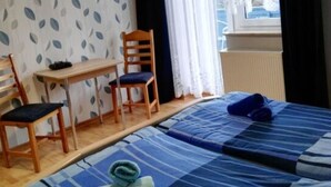 Ett rum med två sängar, ett bord och en stol.