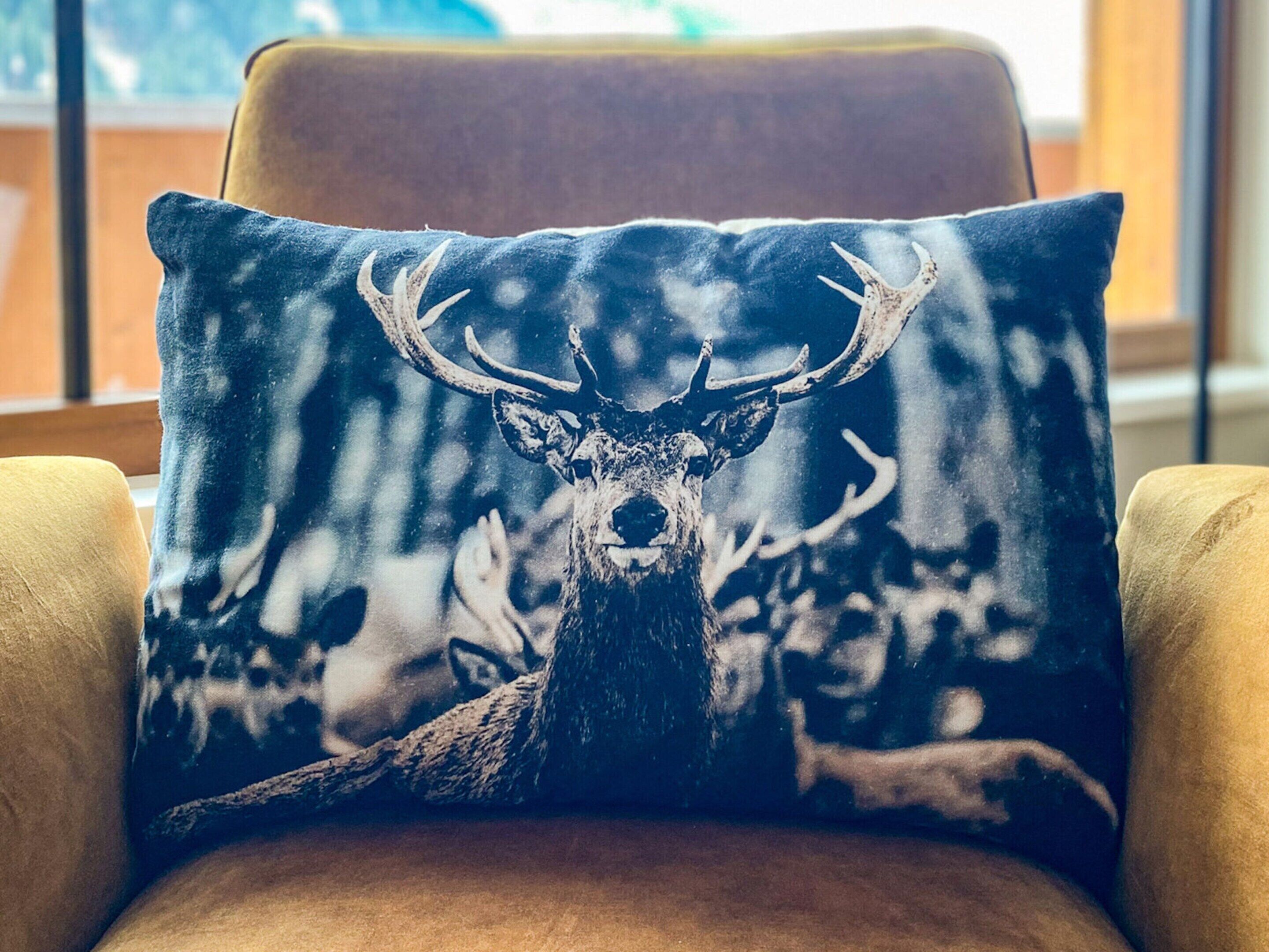 A chair with a cushion featuring a deer illustration.