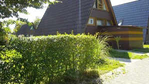 Een huis met een steil dak en een zichtbaar dakraam.