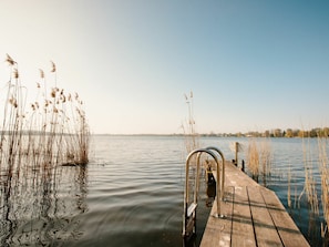 A wooden dock extending into calm water with tall grasses on either side. - Holiday Apartment in Werder (Werder (Havel))