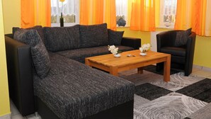 A living room with a sectional sofa, a wooden coffee table, and two armchairs. - Beach Crab Modern Retreat (Dornum)