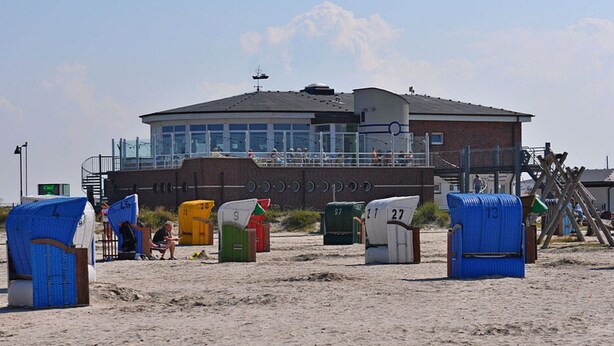 A beachside building with a lifeguard tower, beach huts, and a sandy beach. - Beach Crab Modern Retreat (Dornum)