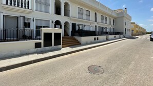 A row of white buildings with balconies, a manhole cover on the street, and a clear sky. - Belvilla by OYO Casa del Segura (Formentera de Segura)