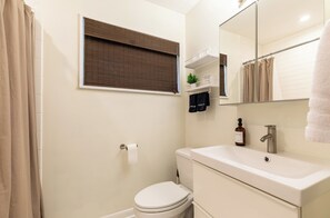 Une salle de bain avec des toilettes, un lavabo et un miroir.