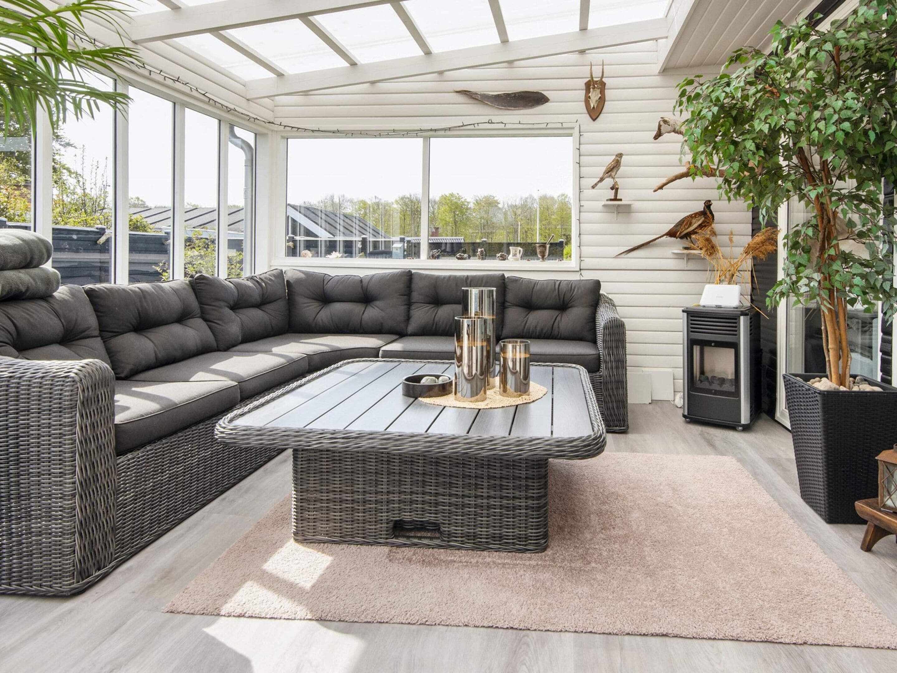 A modern living room with a sectional sofa, a coffee table, and a fireplace.