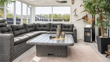 A modern living room with a sectional sofa, a coffee table, and a fireplace.