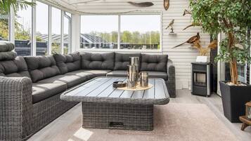 A modern living room with a sectional sofa, a coffee table, and a fireplace.
