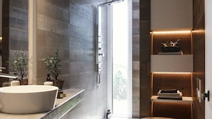 A modern bathroom with a large mirror, two sinks, a shower, and a toilet. There are plants on the counter and a shelf with toiletries. - Holiday Home in Stintino Near Iconic Beaches (Stintino)