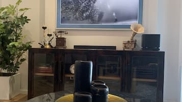 Habitación cuádruple Premium | Zona de estar | Smart TV de 70 pulgadas con canales por satélite