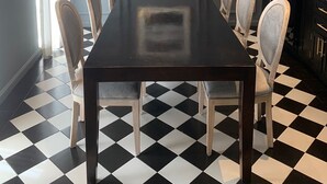 A dining area with a long table, six chairs, and a chandelier. - Posada Valquiria ValQuirico (Tetlatlahuca)