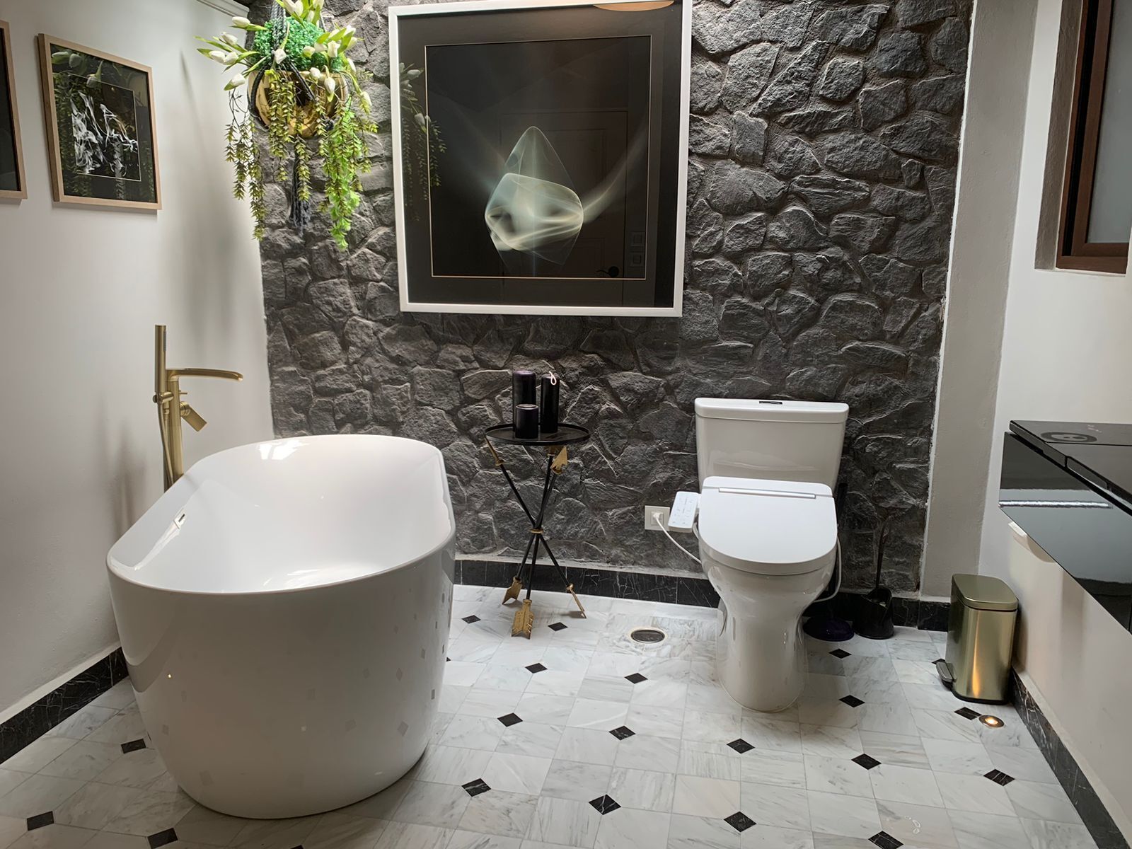 A modern bathroom with a freestanding bathtub, a toilet, and a sink.