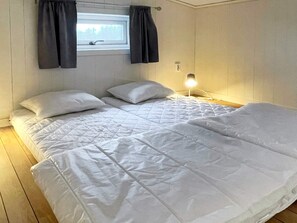 A single-bed room with a window, a bedside lamp, and a wooden floor. - 4 Person Holiday Home in Farjestaden (Farjestaden)