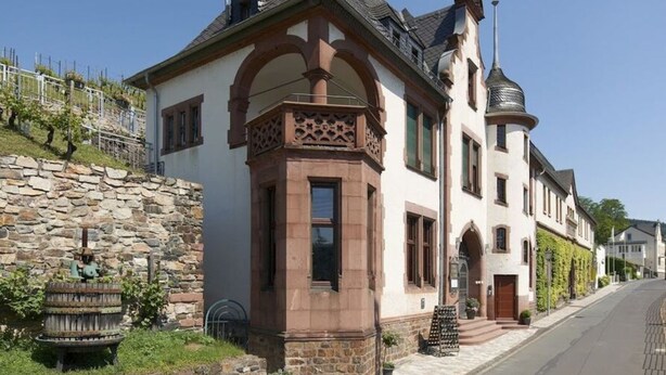 A historic building with a stone facade, arched windows, and a prominent tower. - Apartment Pinot Noir (Lorch)