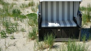 Una silla de playa con un cojín a rayas y una funda blanca que dice "Secadler".