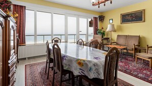 Un comedor con vista al mar, un candelabro y un sofá.