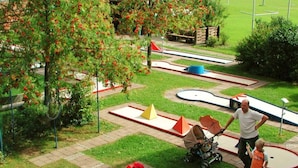 A children's play area with various structures and a tree with red flowers. - Kreuzwiesen Comfortable Holiday Residence (Missen-Wilhams)