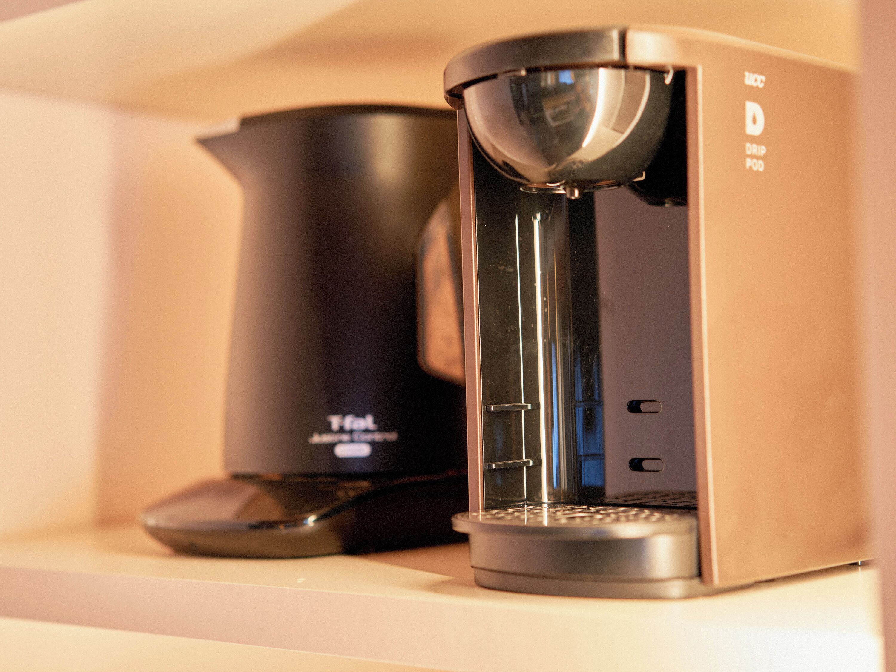 A coffee maker and a drip pod on a shelf.