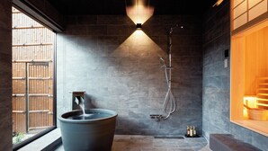 A modern bathroom with a large stone bathtub, a shower, and a wooden bench. - Konjaku-So Nara Naramachi Sauna Villa (Nara)