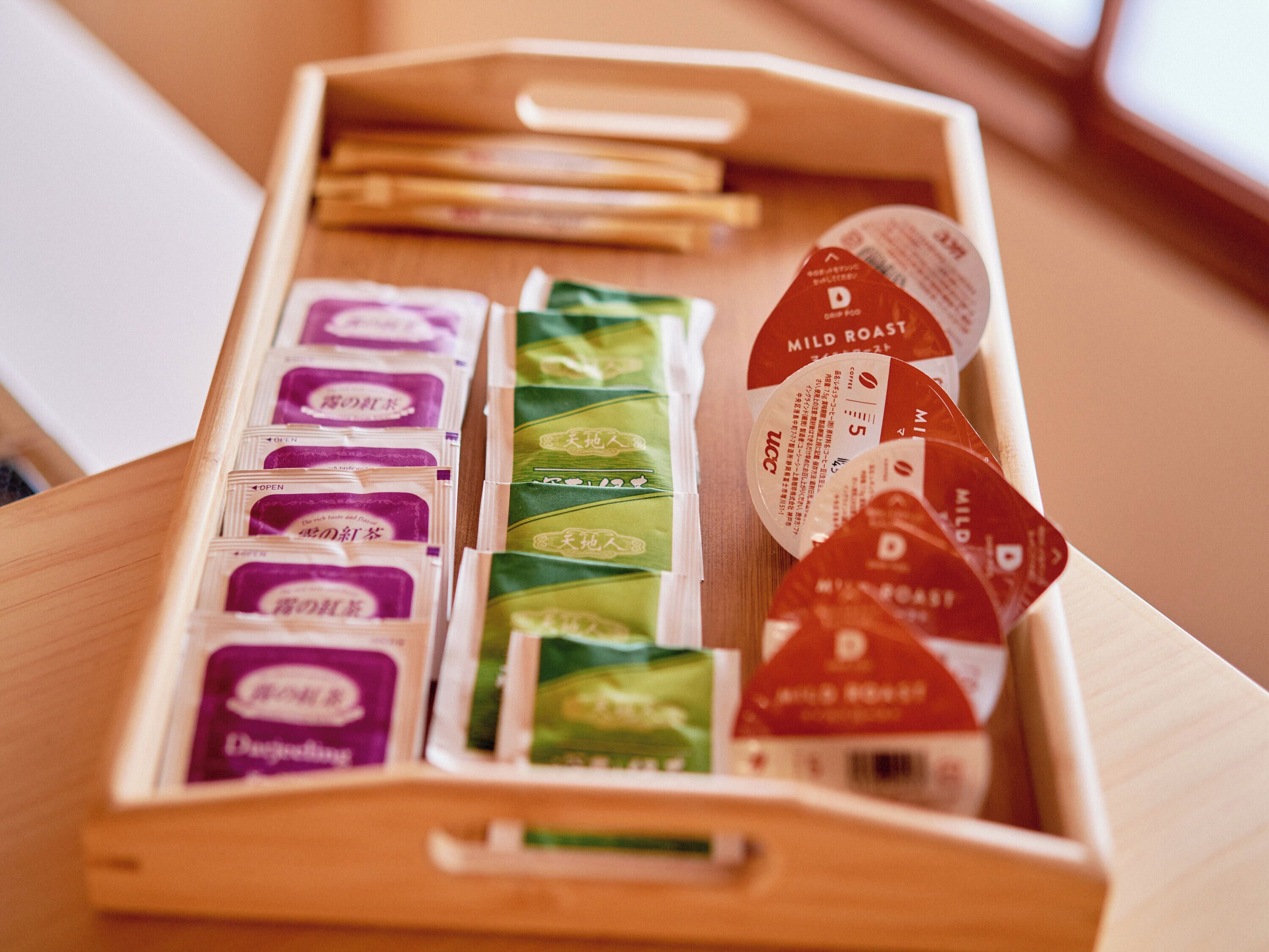 A wooden tray with various packaged items, including tea and snacks.