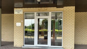 Entrada de un edificio con puerta de vidrio, identificada con 
