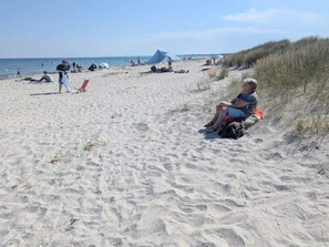 A sandy beach with tents and people. - 2 Person Holiday Home in Albaek (Aalbaek)