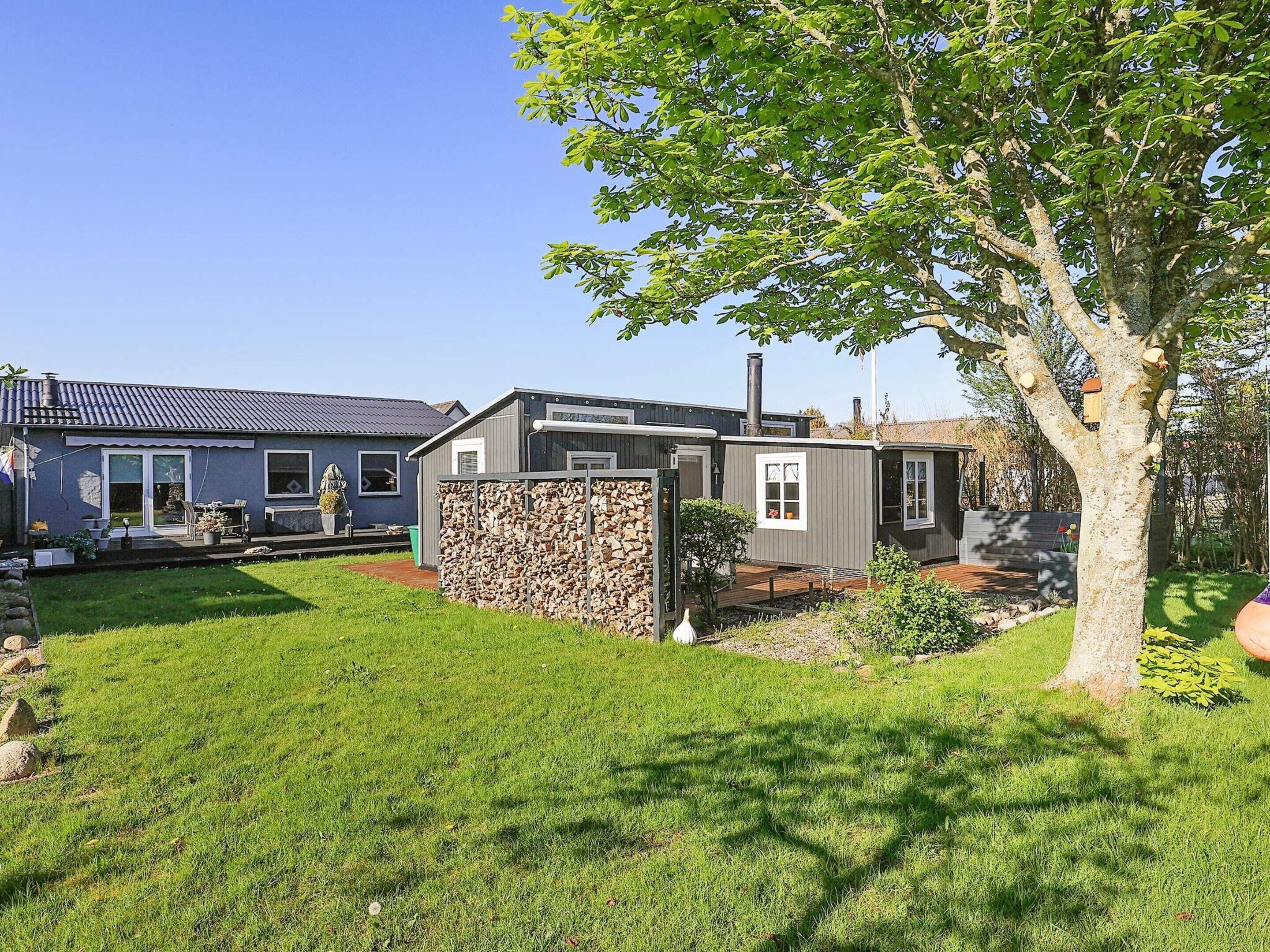 A residential property with a well-maintained lawn, a stone wall, and a variety of buildings including a house and a shed.