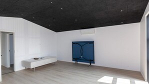 A modern room with a sloped ceiling, a white bench, and a blue metal structure. - 4 Star Holiday Home in Saltum (Saltum)