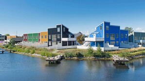 A waterfront property with colorful buildings, a dock, and a calm lake. - 7 Person Holiday Park Home in Ebeltoft (Ebeltoft)
