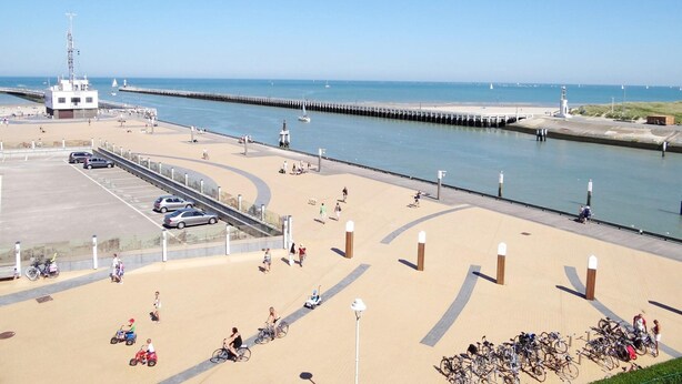 A coastal promenade with a sandy walkway, a pier, and a lighthouse. - Attic Apartment Nieuwpoort by the Sea Wall (Nieuwpoort)