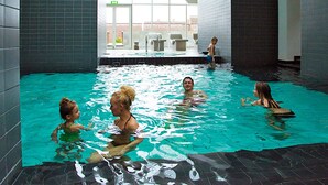 An indoor swimming pool with tiled walls and a sloped ceiling. - 4 Person Holiday Park Home in Romo (Rømø)