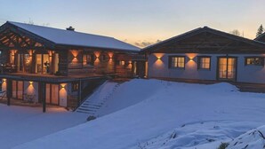 Une cabane en rondins dotée d’un porche abrité et surplombant un paysage enneigé.
