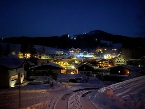 A snow-covered village with illuminated buildings at night. - Skiblickhaus Comfortable Holiday Residence (Russbach am Pass Gschuett)