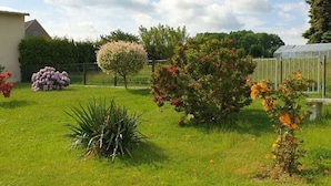 A well-maintained garden with various flowering plants and a small tree. - Ottenhain Natural Paradise (Kottmar)