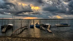 Un puerto deportivo con barcos amarrados a muelles de madera bajo un cielo nublado.