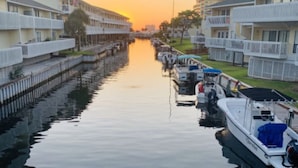 Un canal bordé de bateaux et d’immeubles d’habitation.