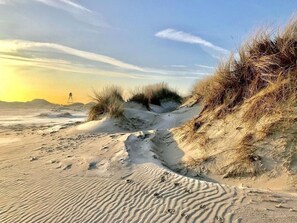 A sandy beach with dunes and footprints. - Nice House on the Golf Course With Sauna (Hollum)