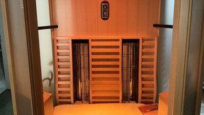 A compact room with a bed, a small clock, and a control panel on the wall. - Baldauf Modern Retreat (Riedenburg)