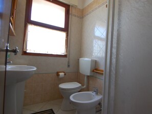 A small bathroom with a toilet, bidet, and sink.