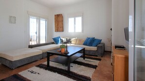 Un salon moderne avec un canapé, une table basse et un téléviseur.