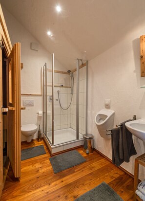 A bathroom with a glass-enclosed shower, a toilet, a bidet, and a sink.