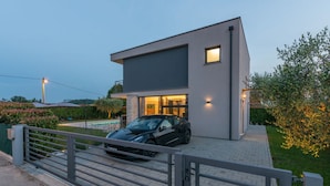 A modern two-story house with a car parked in the driveway. - Belexo - Luxury Home Istria (Porec)
