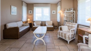 A cozy living room with a sofa, two armchairs, a coffee table, and a bookshelf. - Villa in St-idesbald Near Ster der Zee Beach (Koksijde)